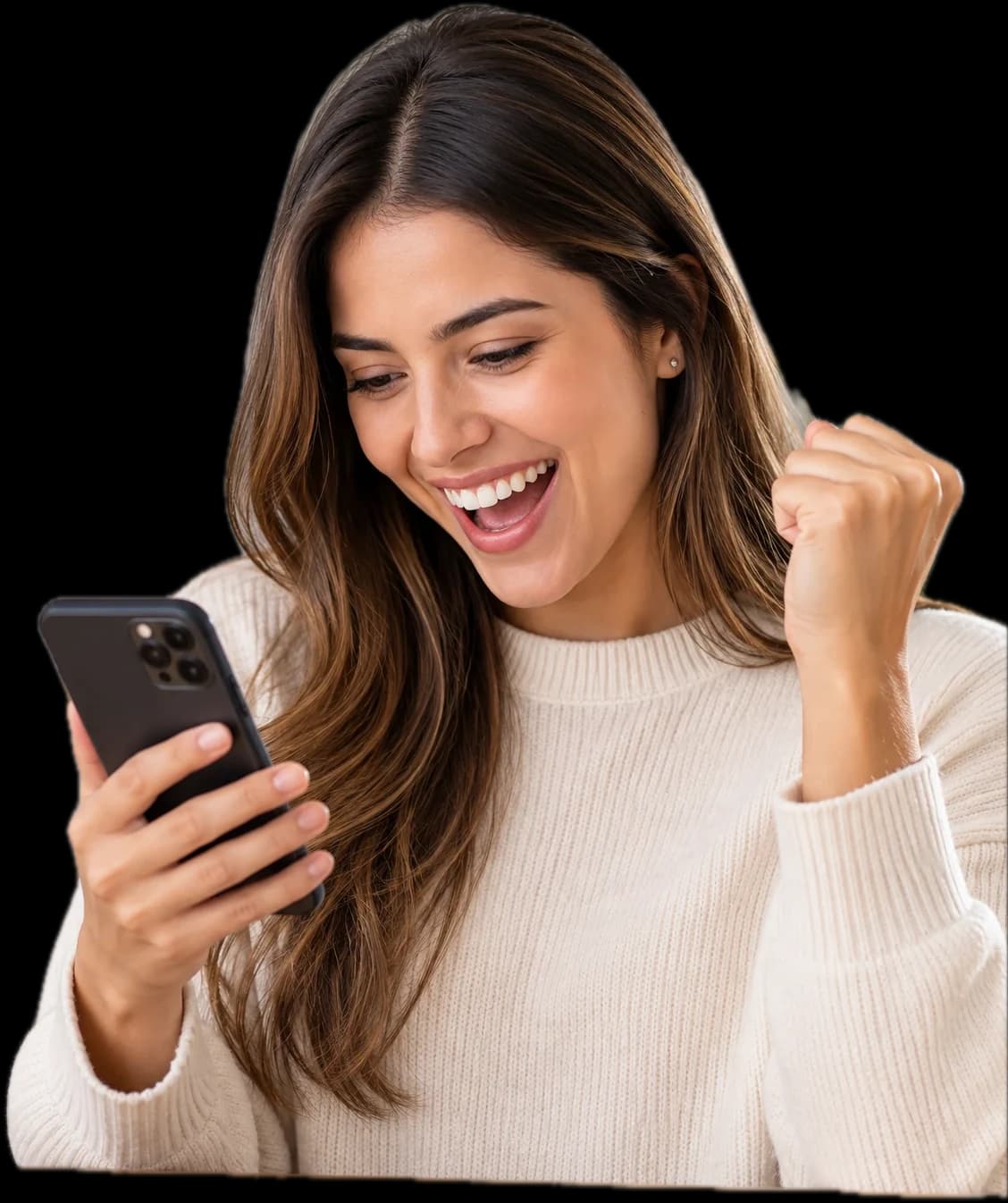 Una mujer sonríe y levanta el puño mientras mira su teléfono.