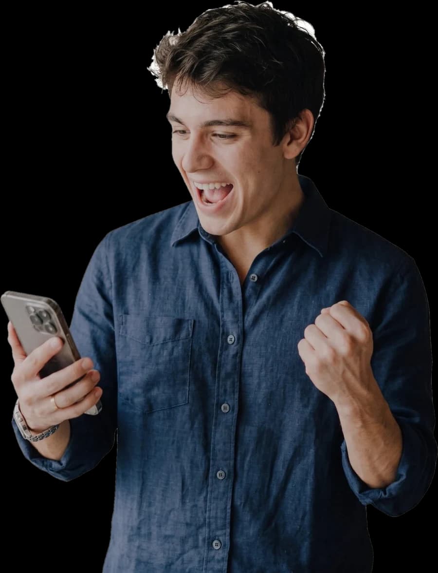 Un comerciante celebra con el puño cerrado mientras mira su teléfono.